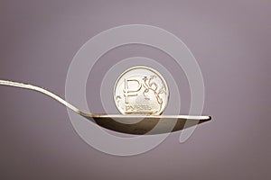 On a gray background teaspoon in which the Russian ruble