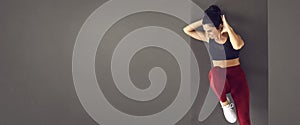 Gray banner with happy fit woman doing abs exercise on sports mat during workout at the gym