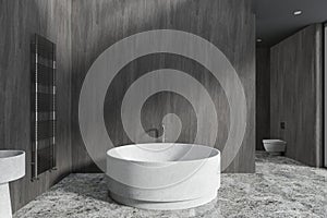 Gray bathroom interior with round bathtub
