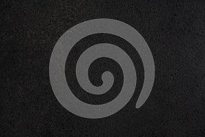 Gray-black granite countertop texture. Black background with splashes of shiny pebbles