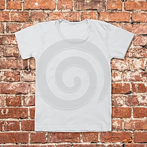 Gray blank t-shirt on dark brick background