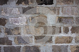 Gray block wall background. Grey textured building exterior surface with rough stacked big bricks. Tiled structure of stonewall