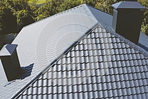 Gray-blue metal roof tiles on the roof of the house. Corrugated