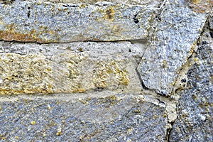 Gray blue old wall made of colored stones and cement