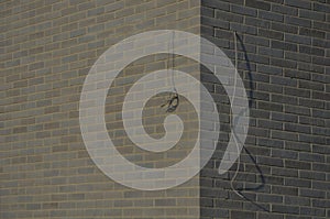 gray brick cladding of a house or garage. the cables routed to the corner of photo