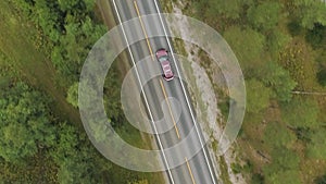 Gray Car is on Straight Road in Green Forest in Norway in Summer Day. Aerial Vertical Top-Down View. Vertical Video