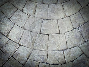 Gray cobblestone bricks floor with a curve of half-circle pattern as background texture