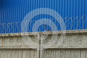 Gray concrete fence with iron barbed wire