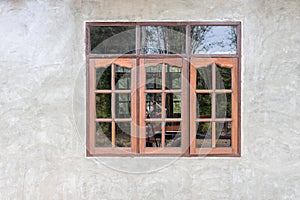 A gray concrete wall background decorates an old wooden glass window