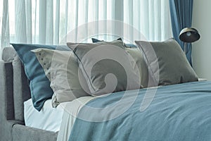 Gray and deep blue pillows setting on bed in deep blue color scheme