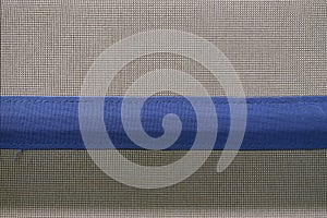 Gray dense fabric with a horizontally blue stripe sewn on it.