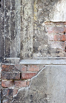 Gray, dilapidated facade with bricks