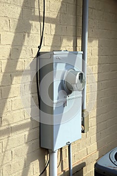 Gray electrical meter and panel on house