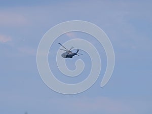 A gray English coast guard helicopter flies in the sky off the English coast near Falmouth