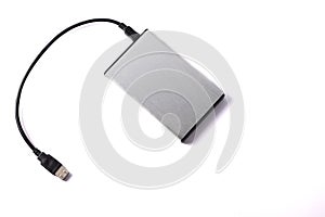 Gray external hard disk with black USB cable on white background