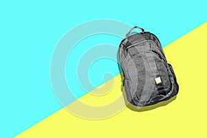 Gray fabric backpack. On a blue yellow background. Minimalism. Travel concept. Accessories. Fashion