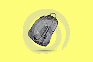 Gray fabric backpack. On a yellow background. Minimalism. Travel concept. Fashion