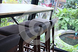 a gray fabric upholstered wooden chair that looks beautiful in a cafe.