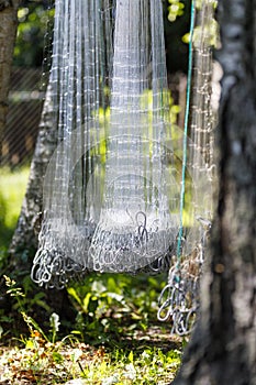 Gray fishing nets hang in sunlight