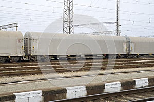 Gray freight train with tented wagons