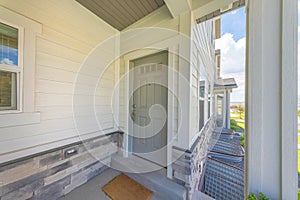 Gray front door of a townhome with glass panes and doormat