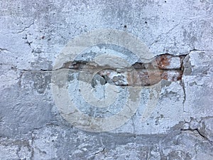 Gray grunge wall texture with red bricks under the concrete