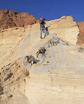 The gray-haired man photographs in a canyon