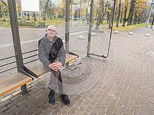 Gray-haired man at a public transport stop