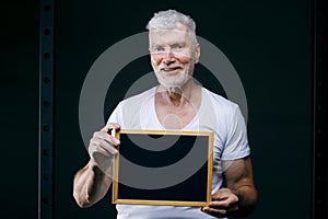 Gray haired senior man with board in his hands. Sport and health care concept