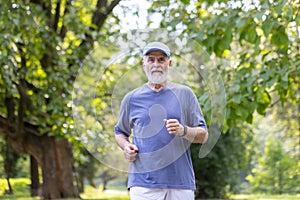 Gray-haired senior man in sportswear running in the park, doing a morning jog, doing sports, keeping fit and leading a