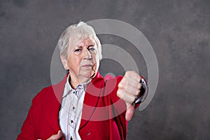 Gray hairy elderly woman showing thumb down