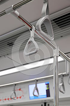 The gray hanging handhold use for standing passengers in a modern metro or train.