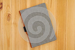 Gray hardcover book on pine wood desk