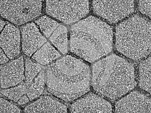 Gray hexagonal pavers with three that are cracked and broken