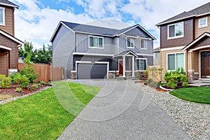 Gray house exterior with dark blue roof and long driveway