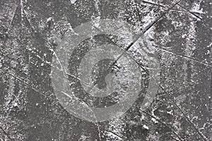 Gray ice rink texture with snow and skate marks. Frozen river abstract background. Scratched ice surface.