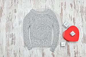 Gray knitted sweater, red heart shaped and silver gift boxes. Fa