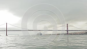 Gray landscape of a big ship sailing under the bridge