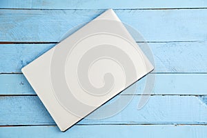 Gray laptop on a blue wooden background. the view from the top