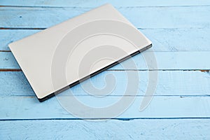 Gray laptop on a blue wooden background. the view from the top