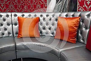 Gray leather sofa with red pillows