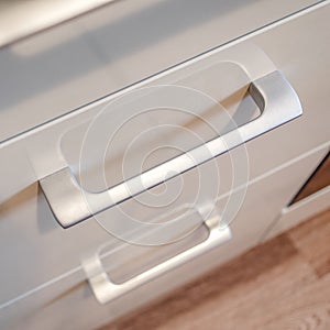 Gray light handle of the kitchen drawer or cabinet.