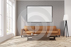 Gray living room with a beige sofa, poster, lamp