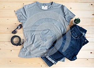 Gray male t shirt mock up flat lay on wooden background. Top front view