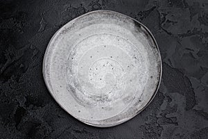Gray matte plate overhead on dark background. Premium empty tableware with dramatic contrast