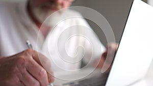 A gray mature man with glasses while working with a laptop. Happy old age, active pensioner, business concept