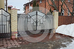 Gray metal gate with a black wrought iron pattern