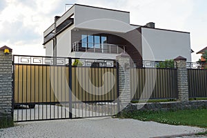 Gray metal gate and fence in front of a private house