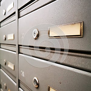 Gray metal mailboxes with name badges close-up.