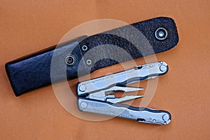 Gray metal multitool and black leather case